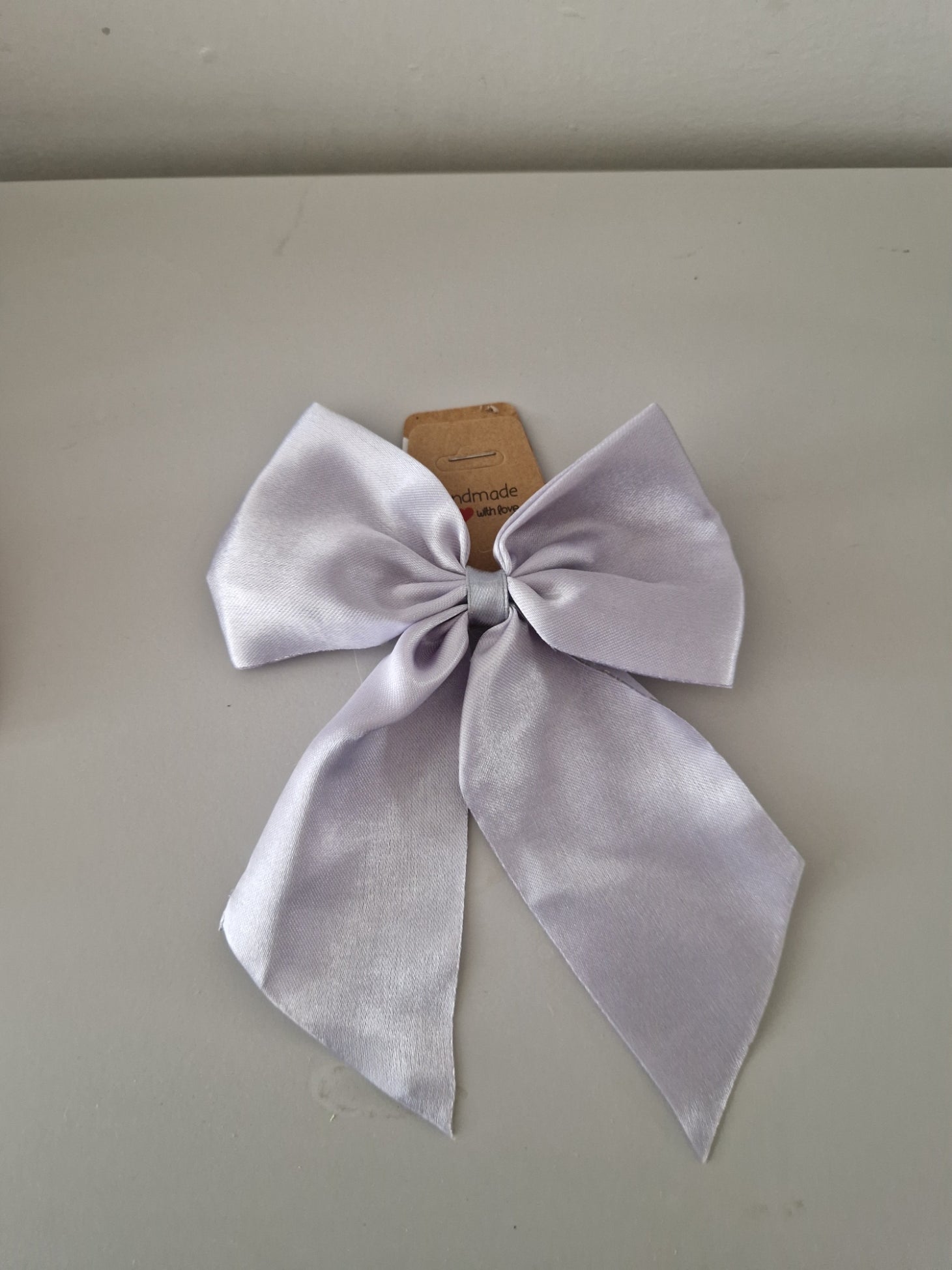Picture of a silver satin bow on a plain background 