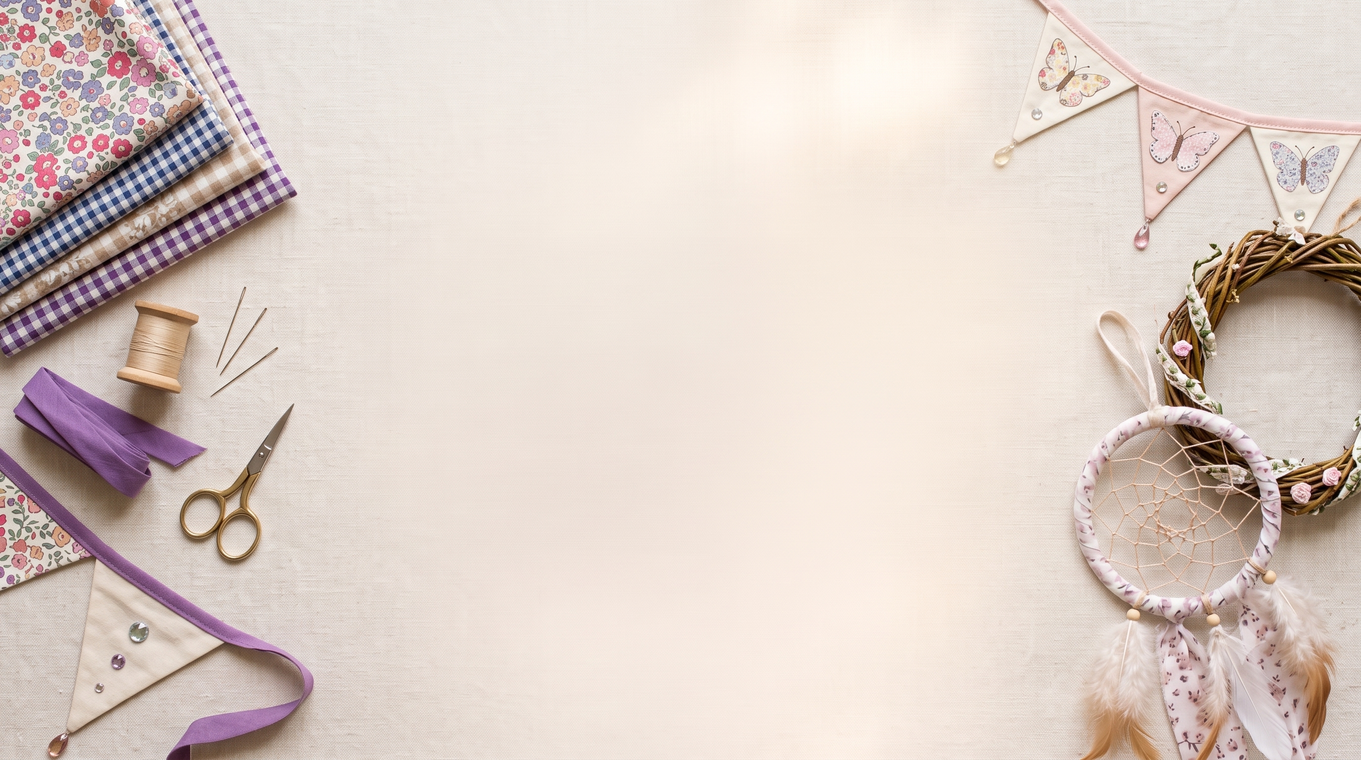 A styled flat-lay of craft and sewing supplies on a light beige fabric background, including patterned fabrics, a spool of thread, scissors, purple ribbon, bunting flags, and a dreamcatcher on the right side with empty space on the left.